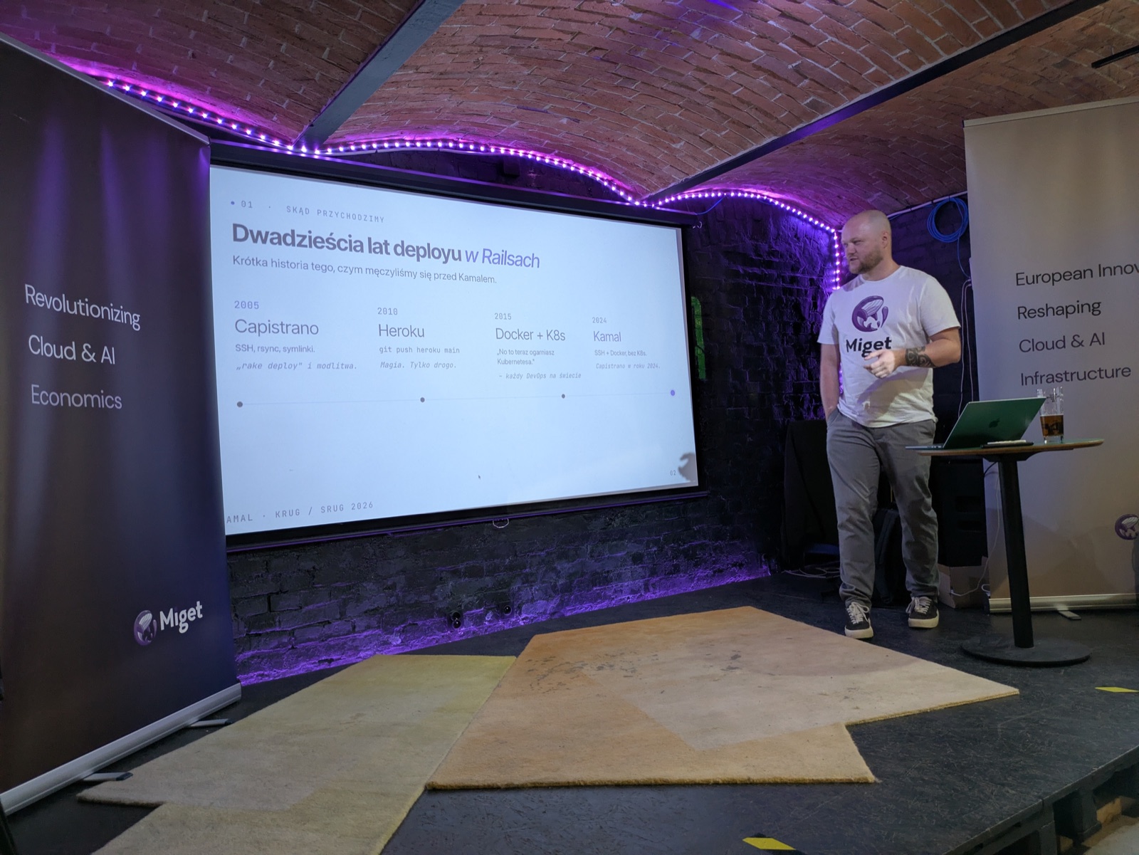 Chris Taraszka giving the Kamal talk at KRUG and SRUG, on stage in front of the twenty-years-of-Rails-deployment slide